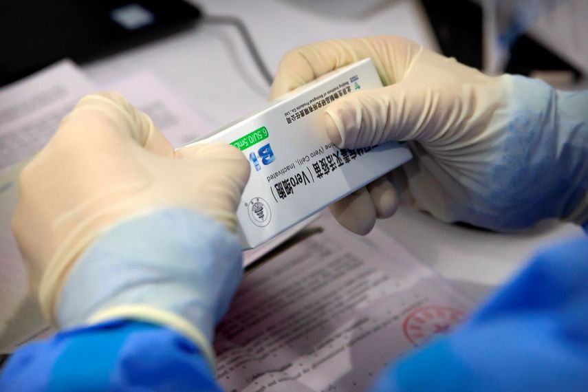 Un trabajador abre una caja de vacuna contra el coronavirus fabricada por una filial de Sinopharm, en una sesión de vacunación a perodistas extranjeros residentes en China, en un centro de vacunación en Beijing, el martes 23 de marzo de 2021.