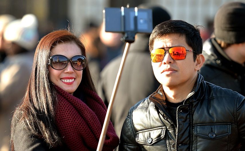 Una turista utitliza un palo de selfie para hacerse una foto. (AP)