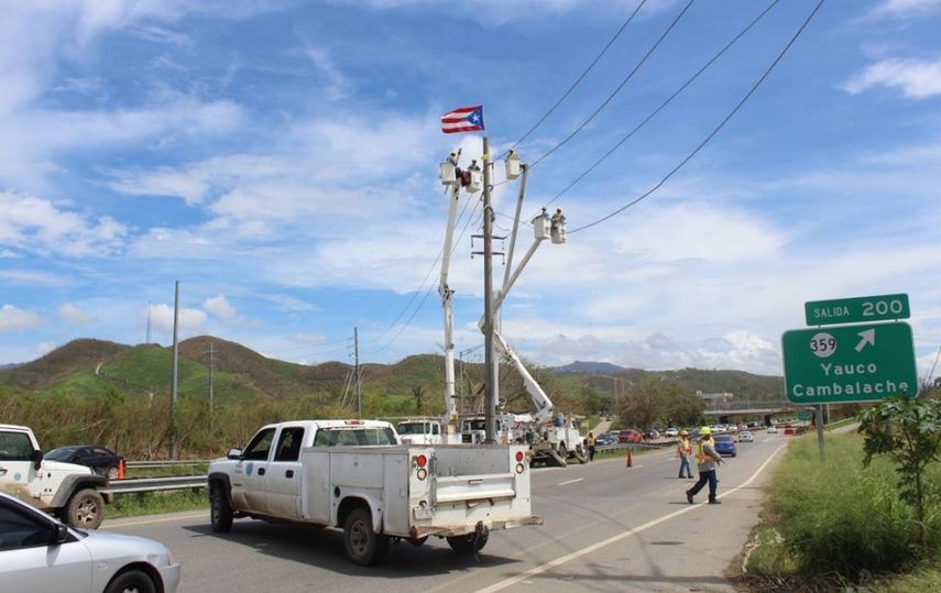 Empleados de la AEE colocaron una bandera de Puerto Rico al tope de un poste de electricidad en una carretera en Yauco.