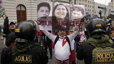 Un opositor al gobierno del presidente Pedro Castillo sostiene fotografías de Castillo, cuñada Yenifer Paredes y su esposa Lilia Paredes con la leyenda Delincuentes, a las afuertas de una corte durante una protesta fuera de un tribunal en contra de Yenifer Paredes, el domingo 28 de agosto de 2020, en Lima.&nbsp;