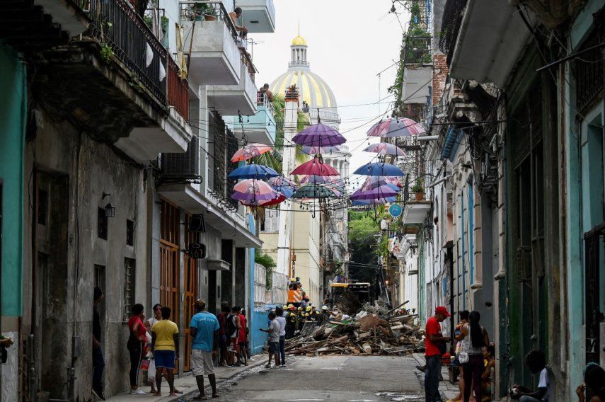 Ciudadanos observan mientras los bomberos retiran los escombros de un edificio que se derrumbó parcialmente en La Habana, Cuba, el miércoles 4 de octubre de 2023.&nbsp;