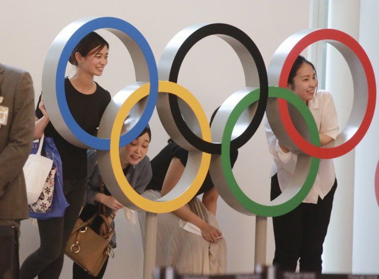 Gente posando para una foto con los anillos olímpicos en el aeropuerto internacional de Haneda, en Tokio, el jueves 8 de julio de 2021. 