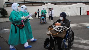 Varias personas que dieron positivo al coronavirus COVID-19 son trasladadas a tiendas en el exterior del hospital del Seguro Social para seguir su tratamiento, en Quito, Ecuador.