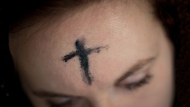 La cruz, dibujada con cenizas de palma.