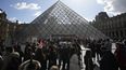 Visitantes esperan frente del Louvre mientras trabajadores de la industria cultural se manifiestan fuera del museo el lunes 27 de marzo de 2023 en París.