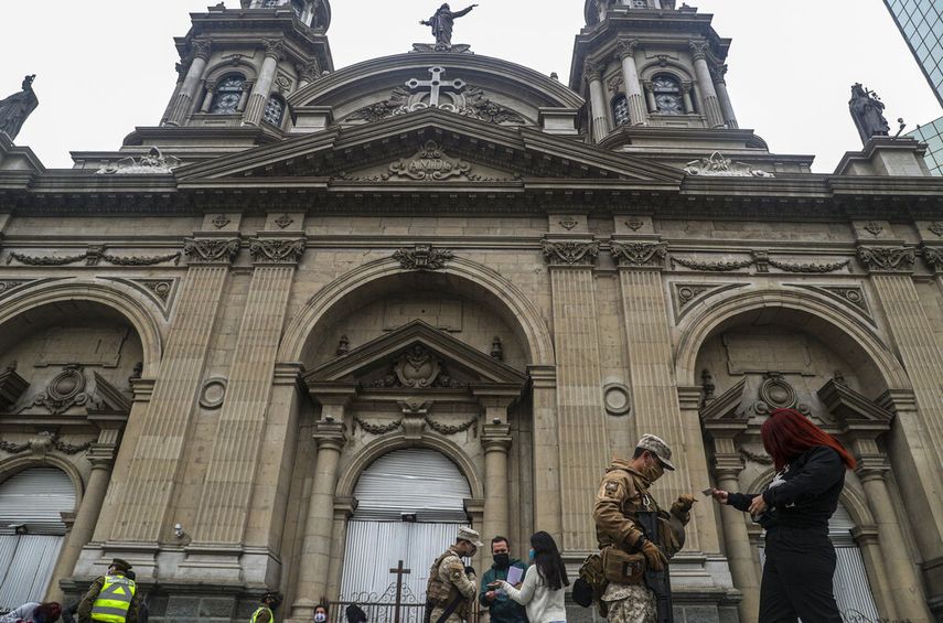 Soldados y la polic&iacute;a nacional forman parte de un operativo para evitar la propagaci&oacute;n del nuevo coronavirus frente a la catedral de Santiago, Chile, el lunes 8 de junio de 2020.