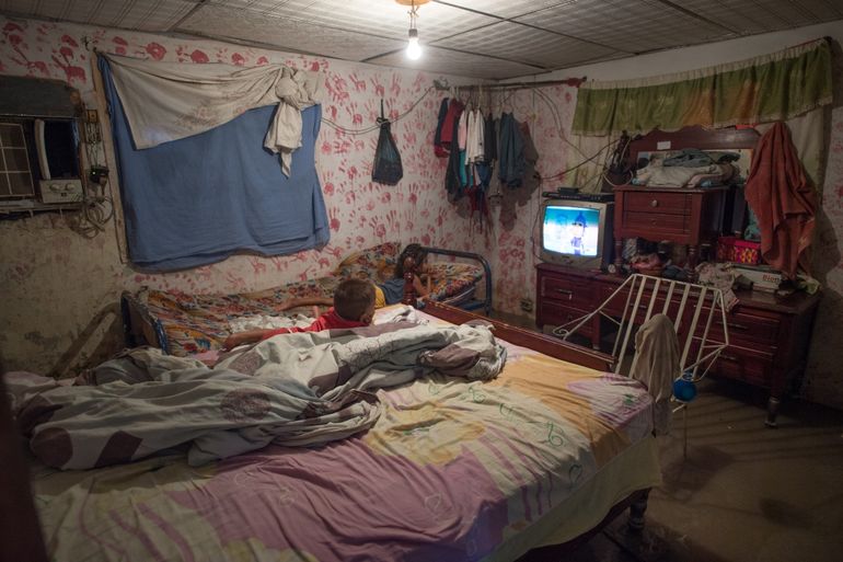 Dos niños miran televisión en la habitación inundada de su casa en la ciudad de La Fortuna en el estado de Zulia, Venezuela