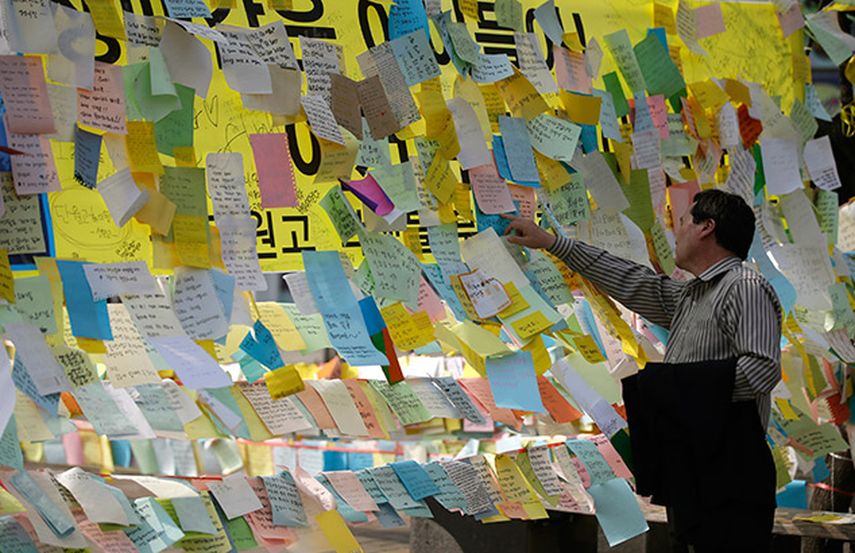 Una persona lee mensajes en los que se desea el regreso con vida de pasajeros del transborador Sewol en Ansan, corea del Sur, Corea del Sur, el jueves 24 de abril de 2014.(AP)