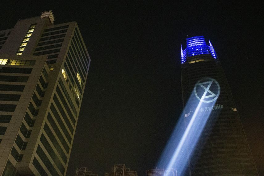 El logo del grupo ambientalista Extinction Rebellion, XR, es proyectado en el edificio Costanera Center mientras sus miembros bloqueaban el tránsito para exigir acciones contra el cambio climático, el viernes 26 de julio de 2019.&nbsp;