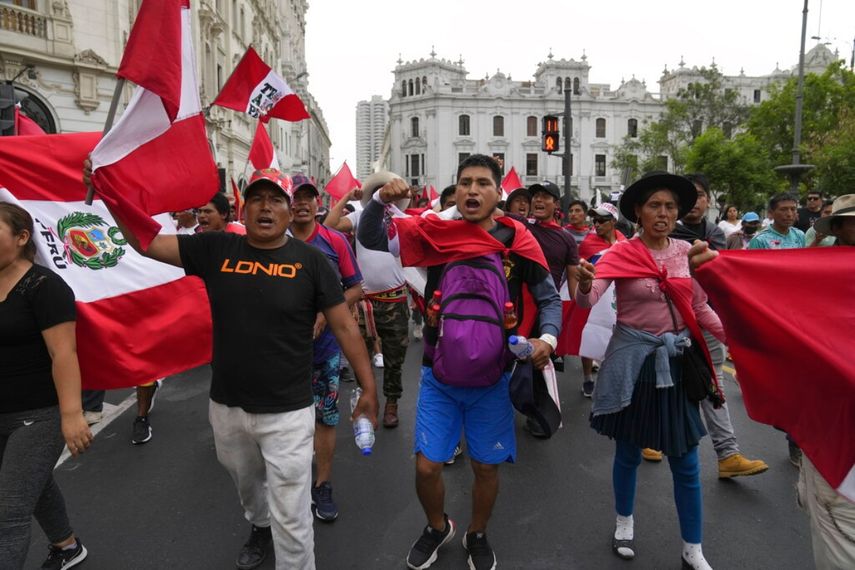Manifestantes que viajaron a la capital desde otras partes del país se enfrentan a una línea de policías antimotines en una marcha contra la presidenta peruana Dina Boluarte en Lima, Perú.