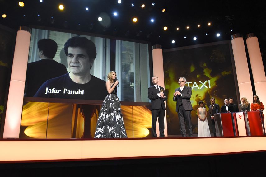 En esta foto de archivo tomada el 14 de febrero de 2015, la actriz alemana Anke Engelke habla cerca de un retrato gigante del director disidente iraní Jafar Panahi mientras el presidente del Jurado Internacional de la Berlinale Darren Aronofsky sostiene el Oso de Oro a la Mejor película para Panahi por su película Taxi Teherán&nbsp;durante la ceremonia de clausura del 65º Festival Internacional de Cine Berlinale en Berlín.