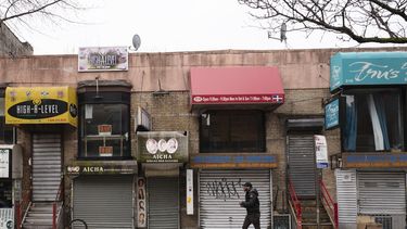 Una persona camina frente a peque&ntilde;os negocios que debieron cerrar por la pandemia de coronavirus en el barrio Crown Heights de Brooklyn, en Nueva York. &nbsp;
