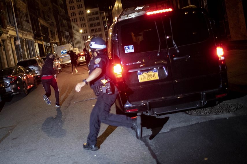 En esta foto de archivo del 1 de junio de 2020, un manifestante huye perseguido por la policía en Nueva York. El video aterrador de un agente de policía de Chicago que mata de un tiro a un chico de 13 años vuelve a echar luz sobre los criterios que rigen las persecuciones a pie.&nbsp;