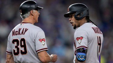 El dominicano Ketel Marte, de los Diamondbacks de Arizona, festeja con el coach de la inicial Dave McKay tras conectar un sencillo de dos carreras ante los Rangers de Texas, en el segundo juego de la Serie Mundial, el sábado 28 de octubre de 2023, en Arlington.