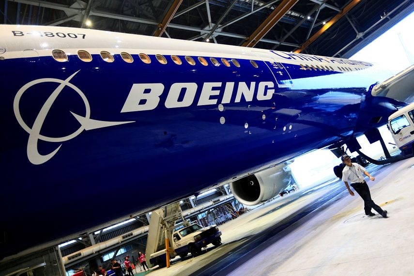 Imagen de archivo de un hombre caminando junto a un Boeing 777. El fabricante de estas aeronaves, con sede en Seattle, EEUU, superó en 2018 las ventas registradas en 2017.