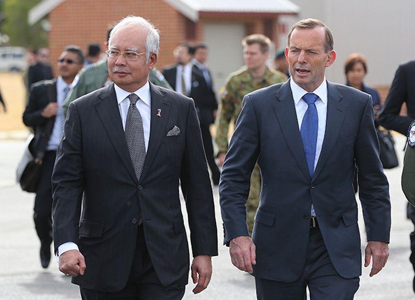 El primer ministro de Malasia, Najib Razak, a la izquierda, y el primer ministro australiano Tony Abbot se dirigen hacia miembros de tripulaciones que participan en la búsqueda de restos del avión perdido de Malasia Airlines en Perth, Australia. (AP)