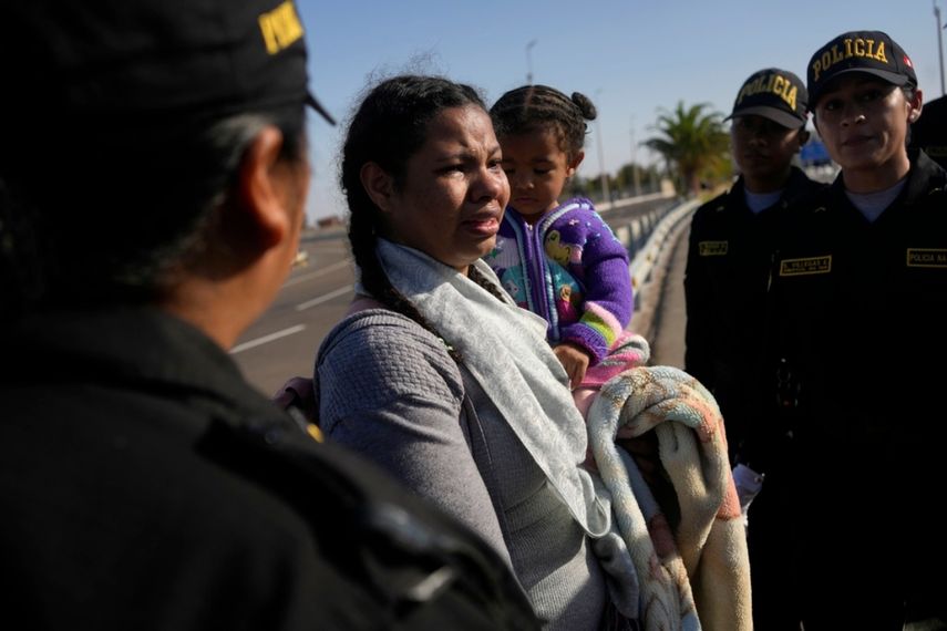 Una migrante venezolana llora cuando la policía la detiene en Tacna, Perú.
