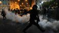 Una nube de gas lacrimógeno rodea a los policías que intentan disipar a simpatizantes del destituido presidente Pedro Castillo, el domingo 11 de diciembre de 2022, en la plaza San Martín, en Lima.&nbsp;