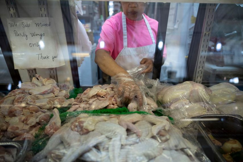 Una empleada en una mercado de carne de aves y res.