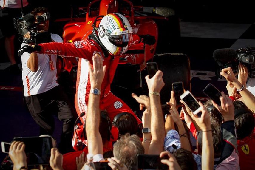Vettel celebra con sus compañeros de la escudería Ferrari.