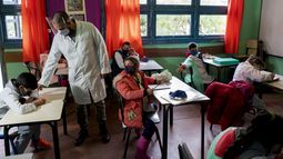 Usando una mascarilla en medio de la pandemia del nuevo coronavirus, un maestro dirige su clase en el primer d&iacute;a de vuelta a la escuela rural cerca de Empalme Olmos, Uruguay, el lunes 1 de junio de 2020