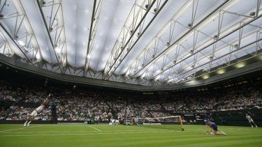 El serbio Novak Djokovic (izq.) le sirve al francés Alexandre Muller bajo el techo cerrado de la cancha central de tenis durante su partido de primera ronda de individuales masculino en el segundo día del Campeonato de Wimbledon 2025 en el All England Lawn Tennis and Croquet Club en Wimbledon, al suroeste de Londres, el 1 de julio de 2025.
