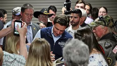Ron DeSantis, gobernador de Florida y candidato a la nominación republicana por la Casa Blanca, firma autógrafos a seguidores en Iowa.