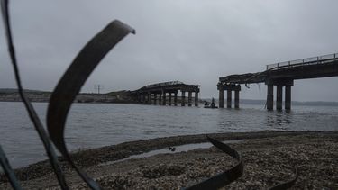 Hombres llevan ayuda humanitaria en una barca a través del río Siverskyi-Donets, frente a un puente destrozado en Staryi-Saltiv, Ucrania, el 27 de septiembre de 2022.&nbsp;