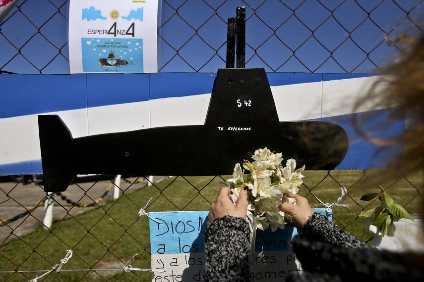Una mujer coloca flores junto a la imagen de un submarino en los d&iacute;as siguientes a la desaparici&oacute;n del ARA San Juan, en Argentina.