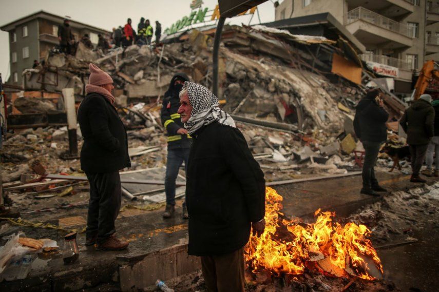 Personas permanecen en las calles al lado de una estructura que se desplomó luego de un sismo registrado en Malatya, Turquía, el 7 de febrero de 2023.