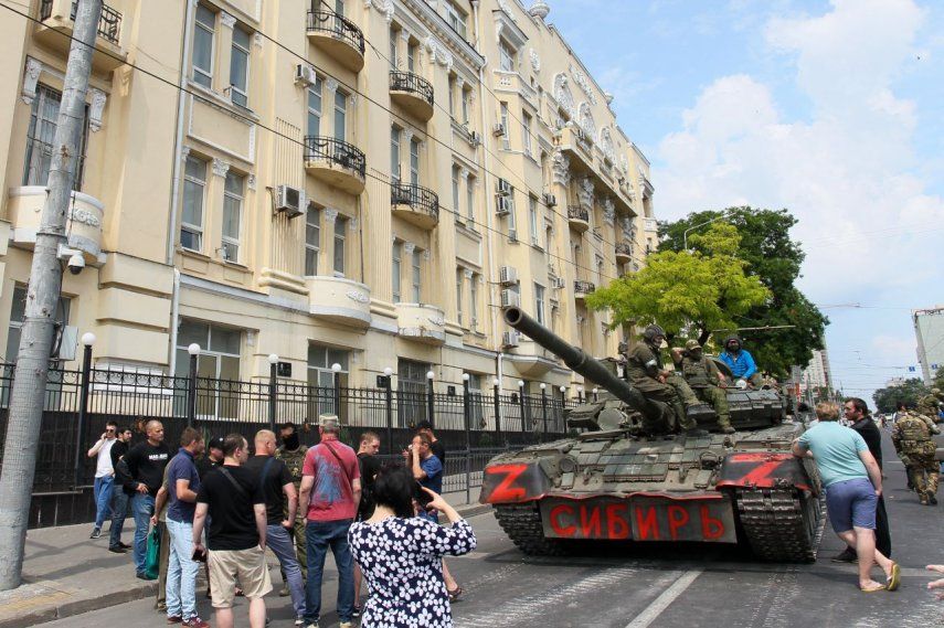 Soldados del grupo Wagner se sientan encima de un tanque en una calle de la ciudad de Rostov-on-Don, el 24 de junio de 2023, mientras pobladores de la localidad se acercan, lo que evidencia el control que tienen en la ciudad.