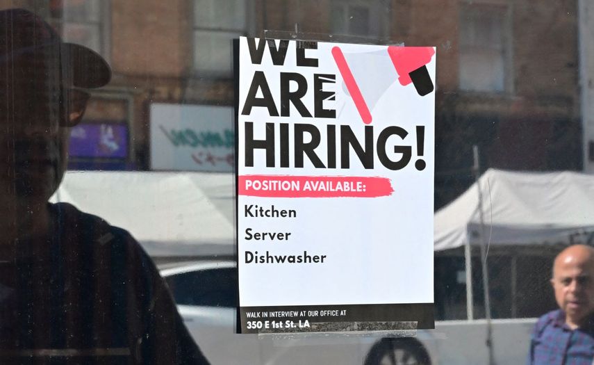 Un letrero anuncia la búsqueda de empleados en un restaurante.