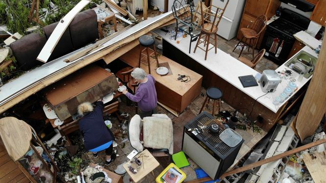 En Chatsworth, Georgia, un par de personas busca entre sus pertenencias en un hogar destrozado tras el paso de un tornado el lunes 13 de abril de 2020.