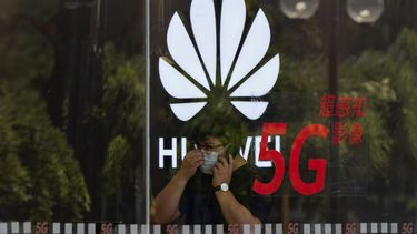 Una persona camina frente a una tienda de la empresa tecnológica china Huawei.