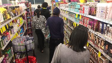 Personas hacen cola en Miami para pagar mercancía por falta de personal, tras aumento de contagios de COVID.