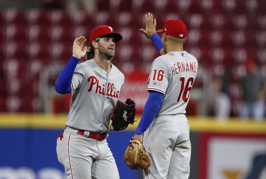 Bryce Harper (izquierda) y el venezolano César Hernández festejan el triunfo de los Filis de Filadelfia, por 6-2 sobre los Rojos de Cincinnati, el martes 3 de septiembre de 2019.