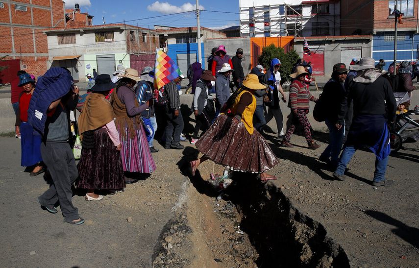 Los partidarios del expresidente Evo Morales pasan por una zanja excavada para evitar que los veh&iacute;culos pasen por la carretera que conduce a la planta Yacimientos Petrol&iacute;feros Fiscales Bolivianos en El Alto, Bolivia, el domingo 17 de noviembre de 2019.