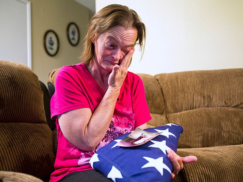 Vicky Olson se limpia las lágrimas mientras conversa el 9 de mayo de 2014 sobre la muerte de su esposo, Michael Olson, ex militar de la marina, en la cochera de la casa de ambos en Phoenix, Arizona. (AP)