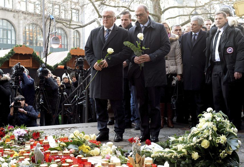 El ministro alemán de Exteriores, Frank-Walter Steinmeier (ci), y su homólogo italiano, Angelino Alfano (cd), colocan flores como homenaje a las víctimas del atentado