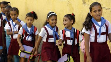 Un grupo de niñas caminan vestidas con el uniforme de una escuela primaria en Cuba.