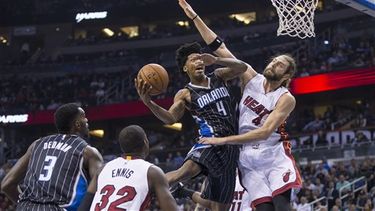 Elfrid Payton (4) se lanza hacia la canasta ante la defensa del jugador del Heat Josh McRoberts. (AP)