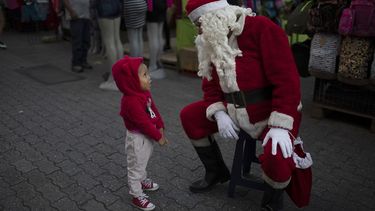 Fredy Parra, vestido de Santa Claus, habla con una niña en una feria navideña en Caracas, Venezuela, el viernes 18 de diciembre de 2020.&nbsp;