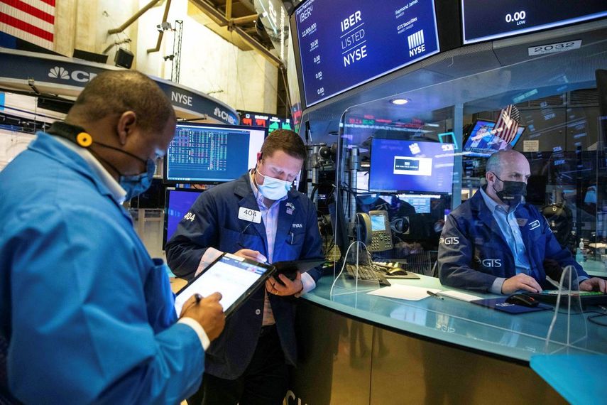 Corredores de la Bolsa de Nueva York trabajan en el piso de remate.