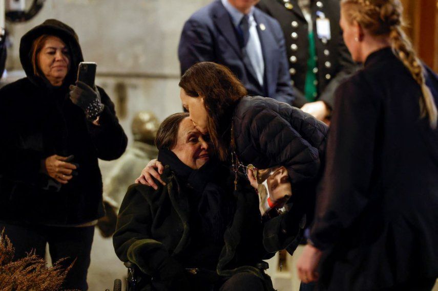 La laureada del Premio Nobel de la Paz, Maria Corina Machado (C-R), besa a su madre Corina Parisca Pérez mientras saluda a los simpatizantes reunidos fuera del Grand Hotel en Oslo, Noruega, en las primeras horas del 11 de diciembre de 2025.