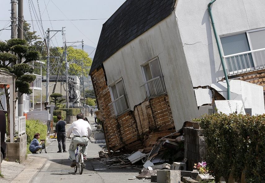 Residentes caminan entre los escombros de un edificio después del sismo de 6,2 grados en la escala Richter, el viernes 15 de abril, en Mashiki (Japón). (EFE)