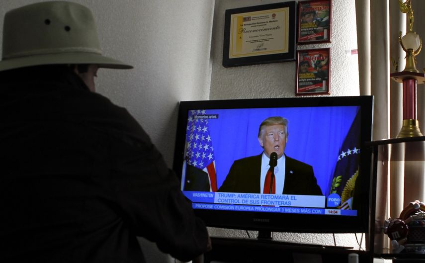 Una mujer sigue las declaraciones del presidente de los EEUU, Donald Trump, quien firmó este miércoles 25 de enero varias órdenes ejecutivas relacionadas con temas de inmigración.