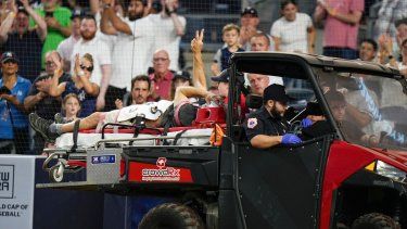 Un camarógrafo resultó lesionado tras un error de lanzamiento por parte del novato de los Orioles de Baltimore Gunnar Henderson, y alza el brazo mientras es trasladado fuera del campo en la quinta entrada del juego de béisbol en contra de los Yanquis de Nueva York, el miércoles 5 de julio de 2023, en Nueva York.&nbsp;