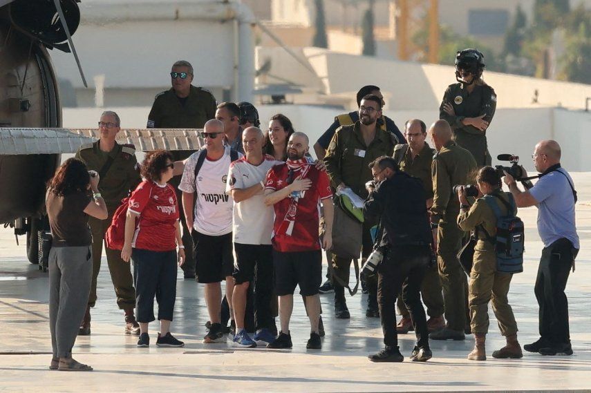 El exrehen israelí Eitan Horn (Centro) hace un gesto al desembarcar de un helicóptero militar israelí en la plataforma de aterrizaje del Centro Médico Ichilov Sourasky en Tel Aviv el 13 de octubre de 2025.