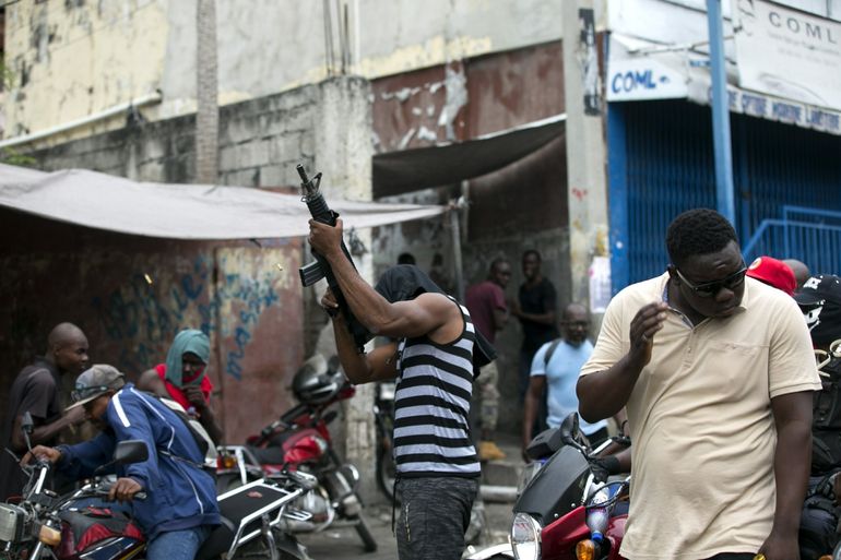 Un oficial de policía fuera de servicio dispara sus armas al aire durante una protesta por el salario y las condiciones de trabajo de las fuerzas del orden en Haití.