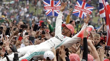 El piloto británico Lewis Hamilton, de Mercedes, festeja con los aficionados después de conquistar el Gran Premio de Gran Bretaña de la Fórmula Uno, en la pista de Silverstone, Inglaterra, el domingo 14 de julio de 2019.